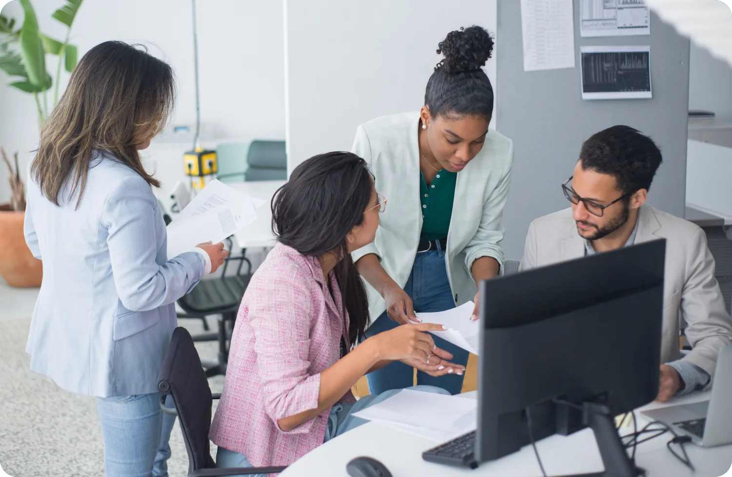 Equipe de fornecedores organizando documentos em frente ao computador